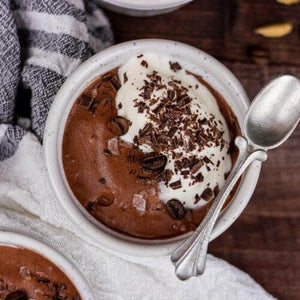 green cardamom and salted chocolate mousse garnished with flake sea salt in a ramikin and spoon atop